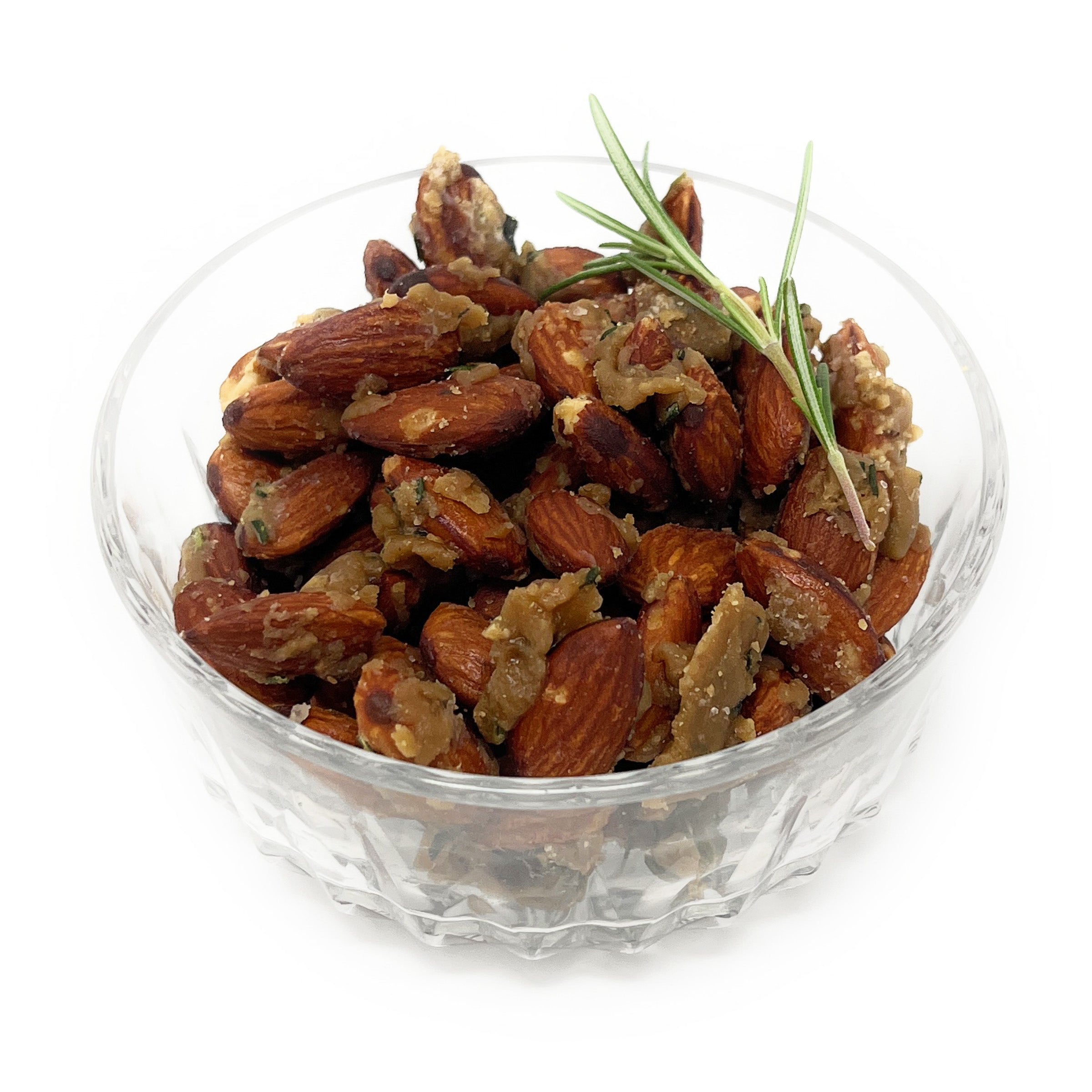 Glass bowl filled with roasted almonds on a white background