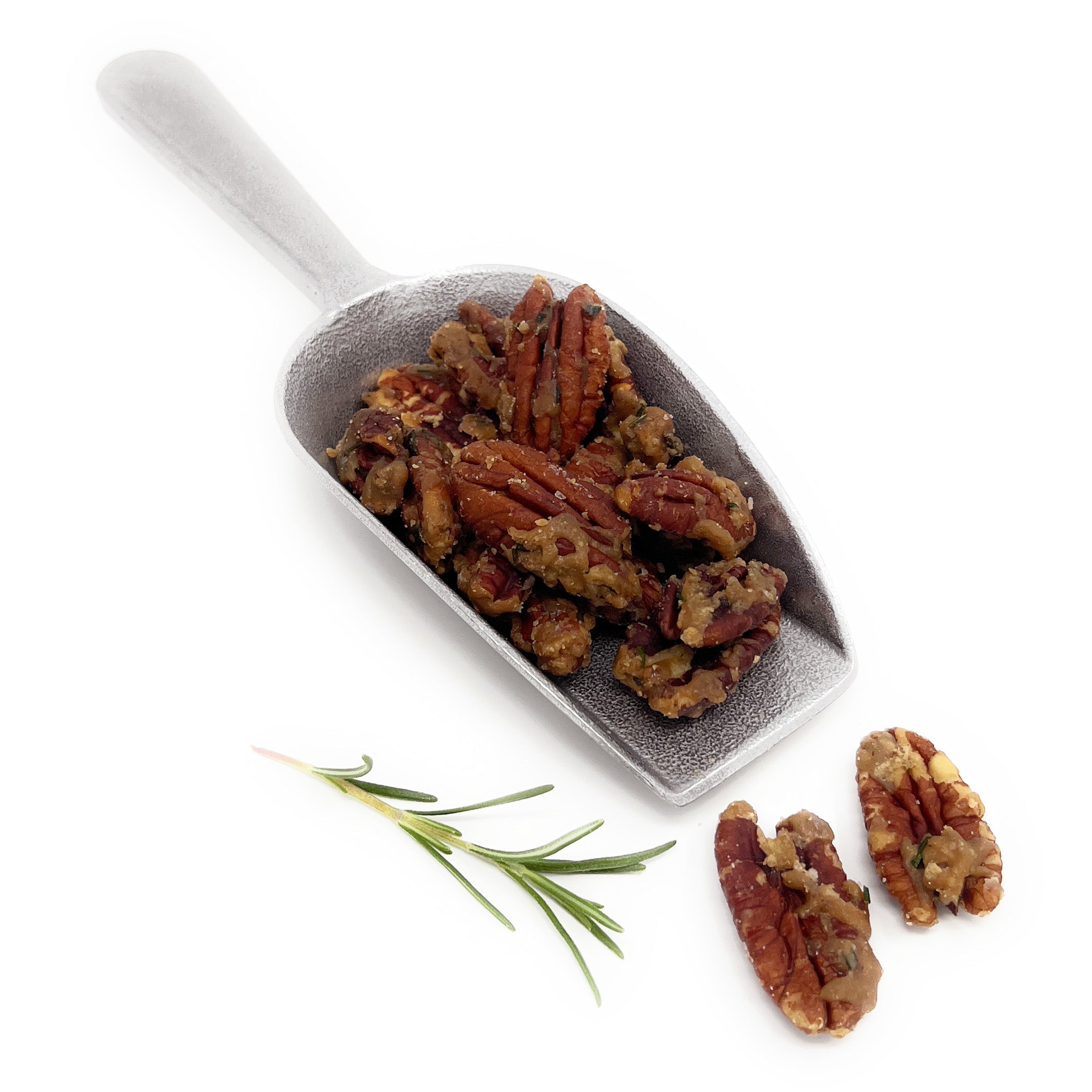 White scoop filled with roasted pecans on a white background